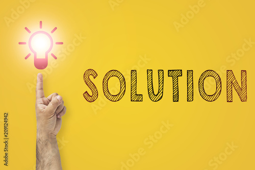 Having new creative idea concept.. Problem solution metaphor. Pointing finger on bulb as a symbol of big new idea. Thinking processes. Light bulb on tip of finger on businessman. Yellow background.