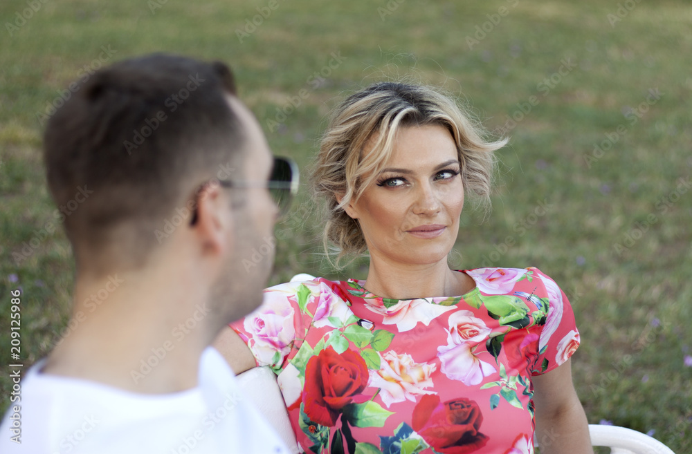 Attractive women looking at man with sunglasses. Women in focus, man blured Attractive women looking at man with sunglasses. Women in focus, man blured