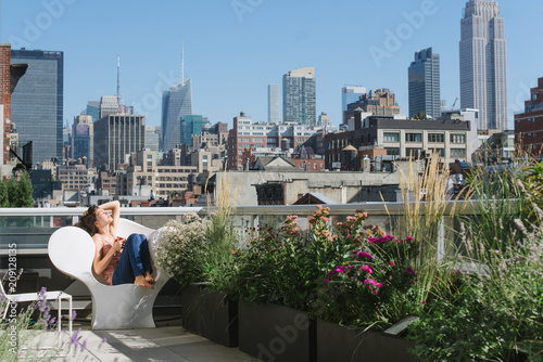 Young woman enjoying sun and coffee on balcony photo