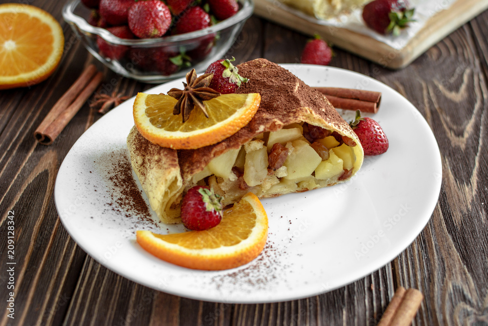 Homemade strudel with apples on a wooden background Homemade strudel with apples on a wooden background
