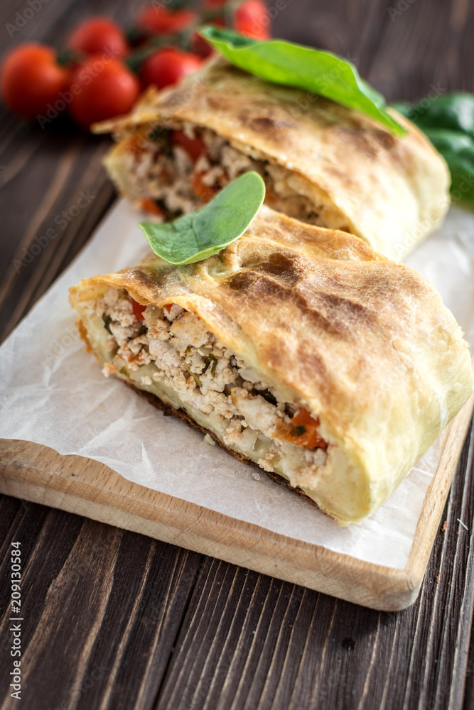 Homemade strudel with meat on a wooden background Homemade strudel with meat on a wooden background