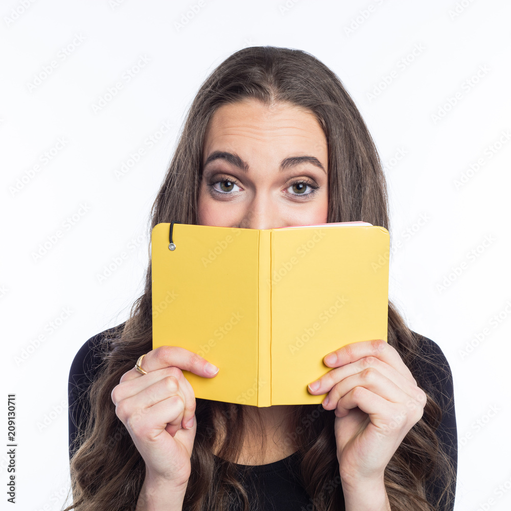 Portrait of cheerful young woman holding yellow notebook Portrait of cheerful young woman holding yellow notebook