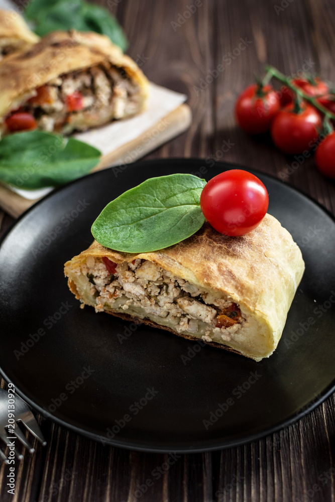Homemade strudel with meat on a wooden background Homemade strudel with meat on a wooden background