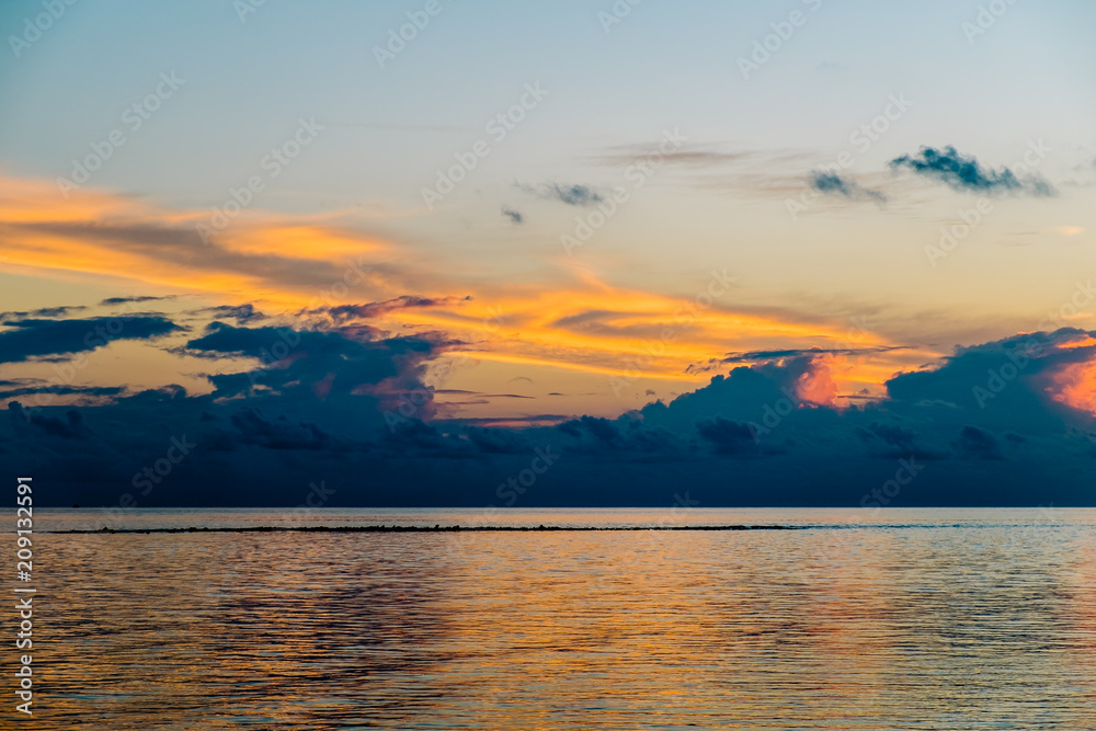 Amazing tropical landscape view. Colorful sky and clouds view with calm sea and relaxing tropical mood. Gorgeous nature background. Maldives, Indian Ocean.