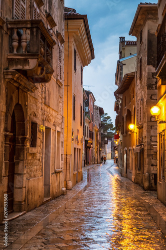 Street in Porec town illuminated by lamps at the evening, Croatia, Europe.