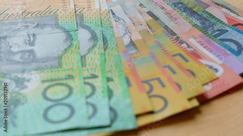 Australian currency slow dolly closeup of fives, tens, twenties, fifties and one hundred notes, shallow DOF.