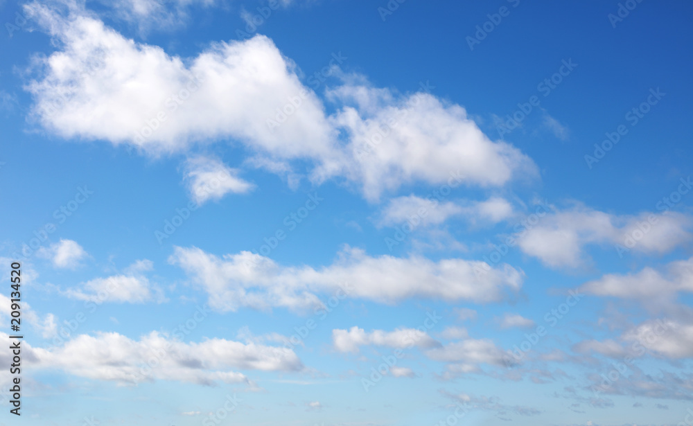 Soft fluffy white clouds in blue sky background