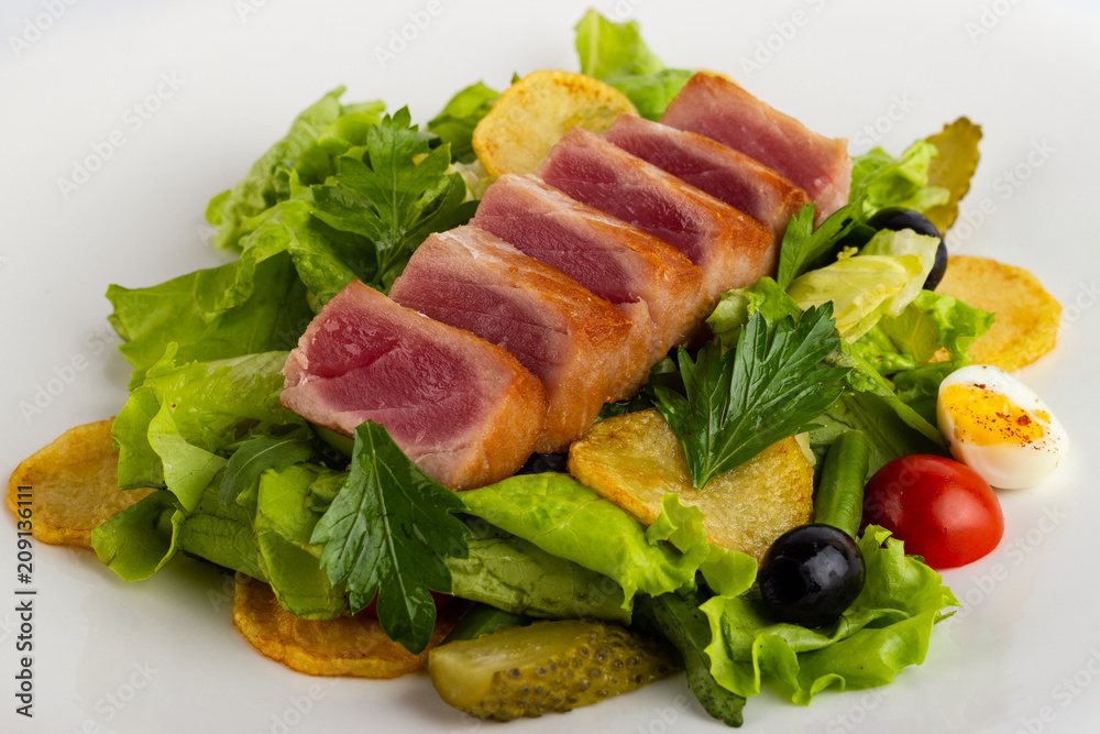 Salad with smoked fish close-up on a white background