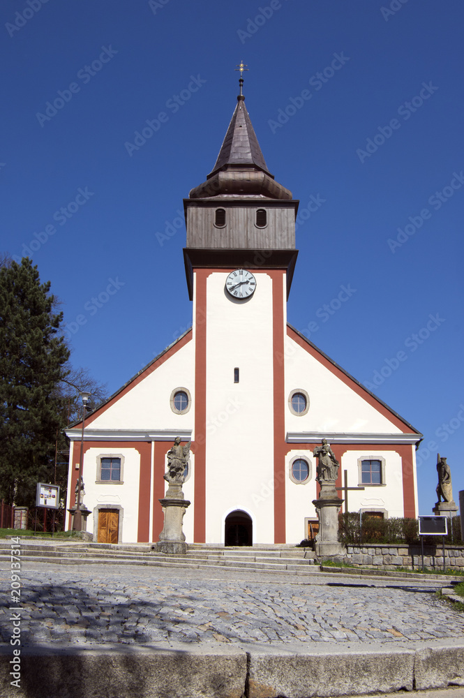 Church of St. Wenceslas in town Svetla nad Sazavou, clock tower, greenery and blue sky