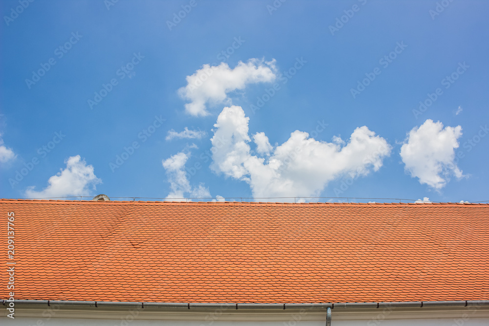 red roof and blue sky horizontal concept with empty space for copy or text red roof and blue sky horizontal concept with empty space for copy or text