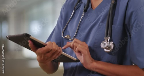 Close up of woman nurse or doctor working on table computer inside hospital, Female medical professional using digital technology, 4k