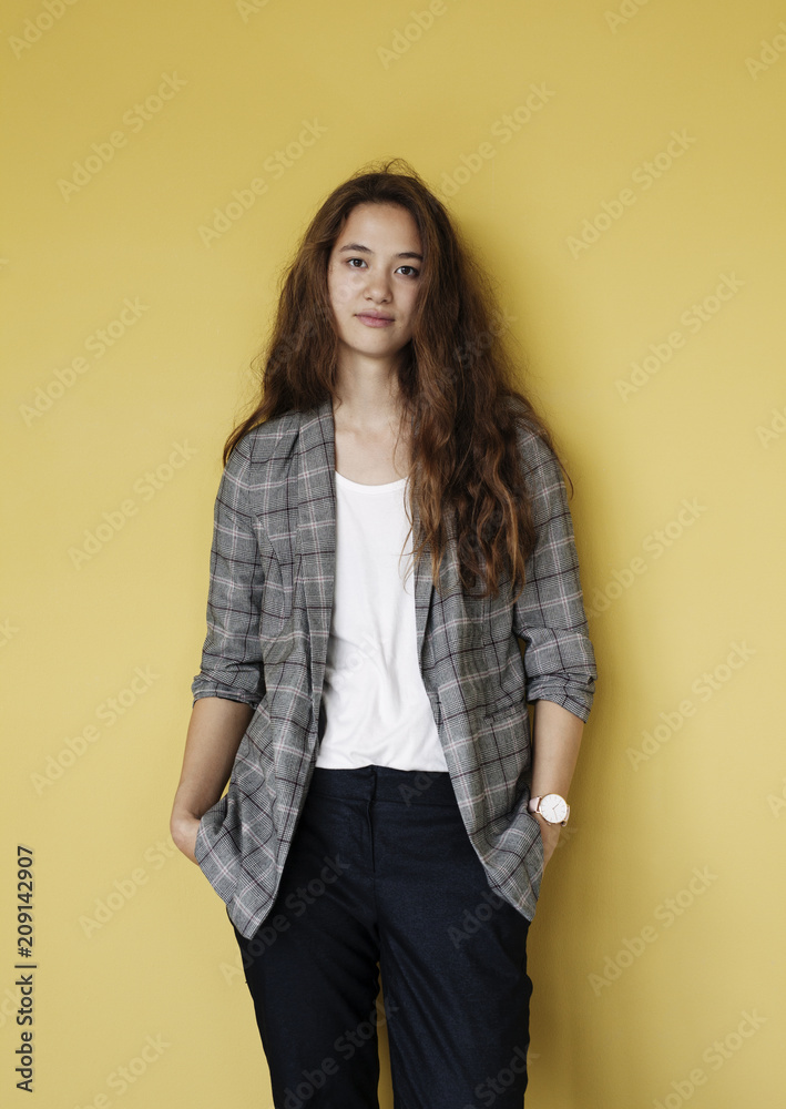 Portrait of a confident young woman against a yellow wall. Portrait of a confident young woman against a yellow wall.