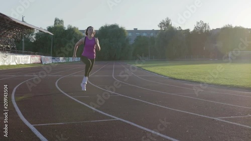 Wallpaper Mural Beautiful fitness girl running through the stadium. Young athlete in training. Steadicam shot Torontodigital.ca