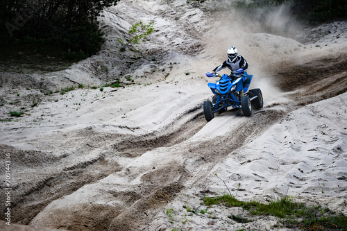 Rider in atv ride on sandy road