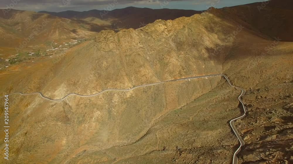 Aerial view of the winding mountain road between two villages of Fuerteventura. Aerial view of the winding mountain road between two villages of Fuerteventura.