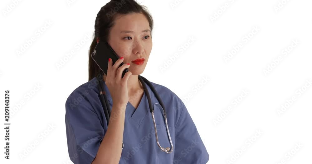 Working millennial nurse dressed in scrubs talking on smartphone device isolated on white backdrop, Serious young Asian medical doctor making phone call on solid blank copyspace, 4k Working millennial nurse dressed in scrubs talking on smartphone device isolated on white backdrop, Serious young Asian medical doctor making phone call on solid blank copyspace, 4k