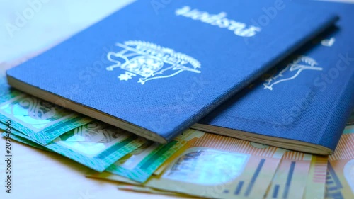 Australian passport and cash travel concept slow dolly closeup macro shot, with hundred and fifty dollar bills, shallow DOF.