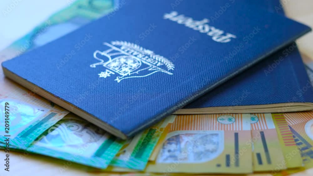 Australian passport and cash travel concept slow dolly closeup macro shot, with hundred and fifty dollar bills, shallow DOF. Australian passport and cash travel concept slow dolly closeup macro shot, with hundred and fifty dollar bills, shallow DOF.
