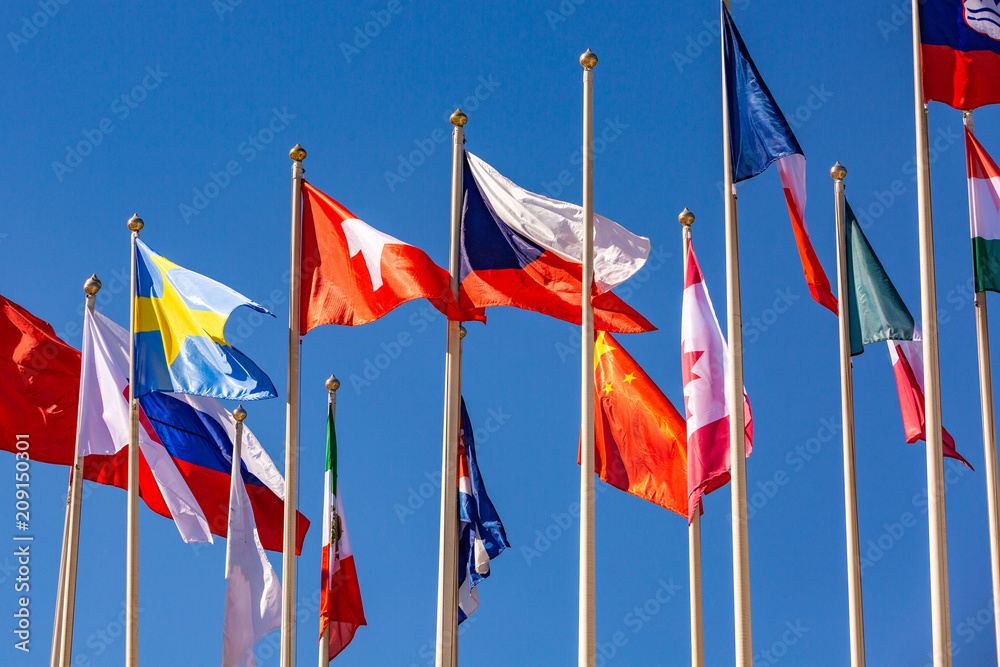 Flags of different countries flutters in the wind against Flags of different countries flutters in the wind against