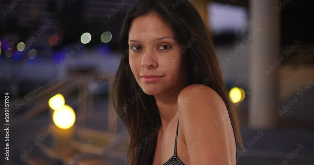 Close-up of beautiful Caucasian girl looking over her shoulder at camera, Portrait of young and attractive female in her 20s downtown in evening, 4k Close-up of beautiful Caucasian girl looking over her shoulder at camera, Portrait of young and attractive female in her 20s downtown in evening, 4k