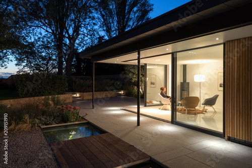 External picture of large glass doors of a garden room at night. photo
