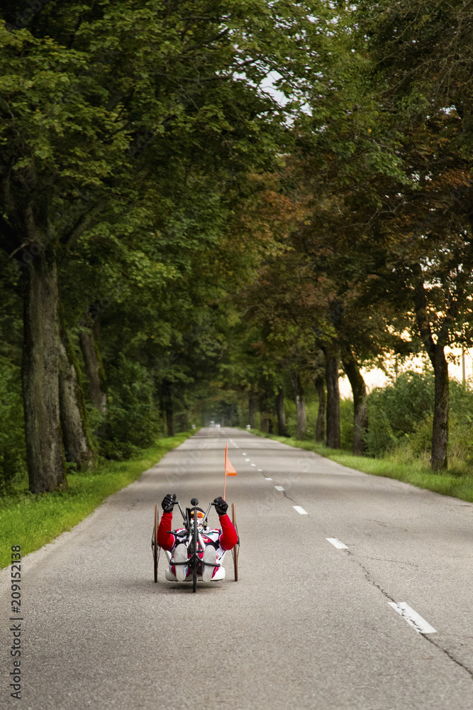 Man riding handcycle down rural road Man riding handcycle down rural road