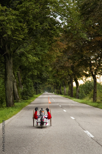 Man riding handcycle down rural road photo