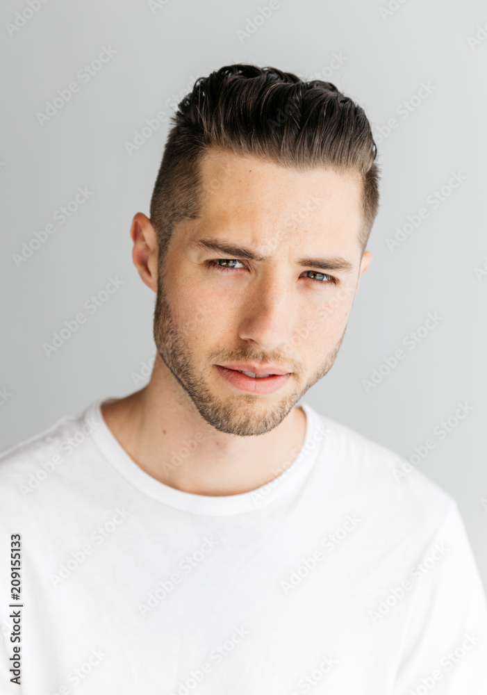 Head shot portrait of young adult male with short hair wearing white t-shirt in studio Head shot portrait of young adult male with short hair wearing white t-shirt in studio