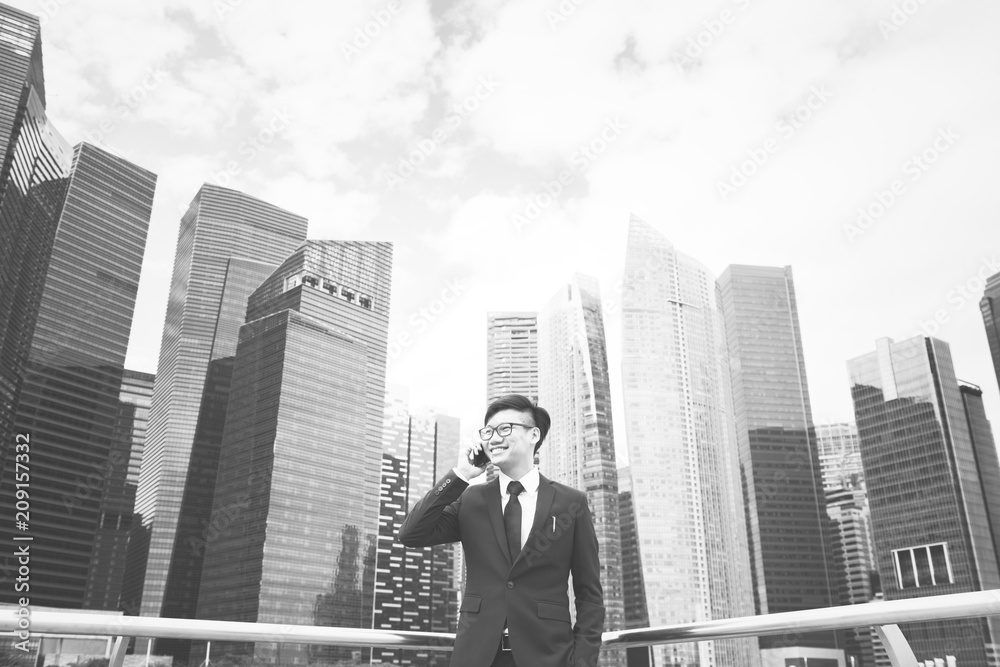 Asian businessman on a phone in the city Asian businessman on a phone in the city