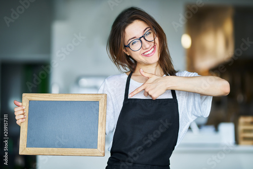 happy waitress holding blank chalkboard sign photo