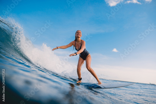 Photography Surfer woman at surfboard on ocean wave