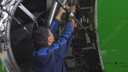 Engine and chassis of the passenger airplane under heavy maintenance. Engineer checks the aircraft engine.