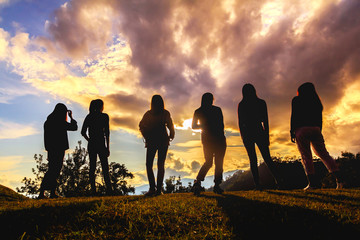 silhouette of friends girls group standing at sunset time
