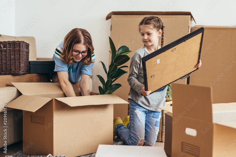 Family unpacking cardboard boxes at new home Family unpacking cardboard boxes at new home