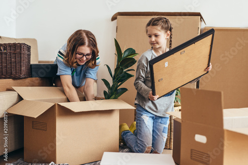 Family unpacking cardboard boxes at new home photo