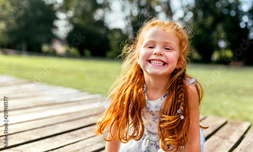 Portrait of a smiling little redhead girl