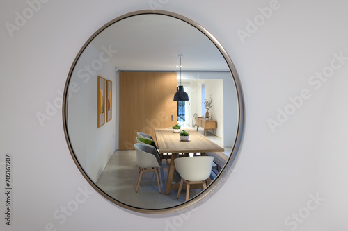 Reflection in a mirror of a dining room illuminated at night.