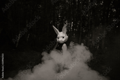 woman in the forest wearing a rabbit mask