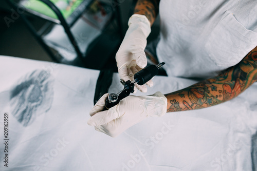 beautiful tattoo artist preparing the tattoo machine