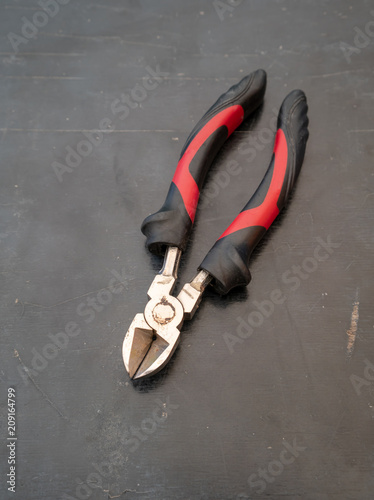 Wire stripper cutter isolated on black stone floor.