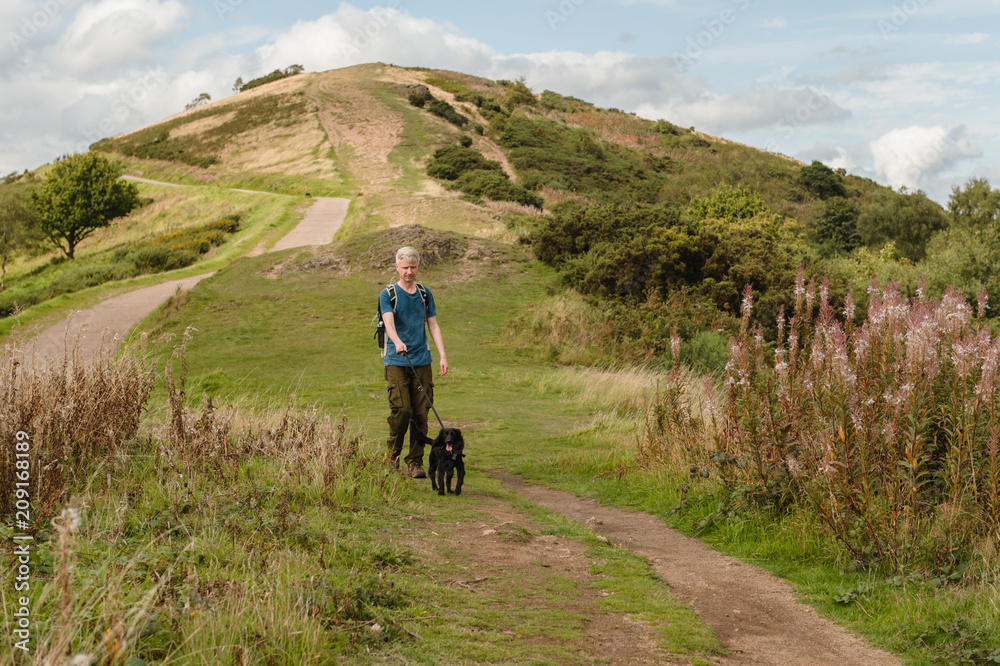 Man walking his dog across the Malvern Hills Man walking his dog across the Malvern Hills