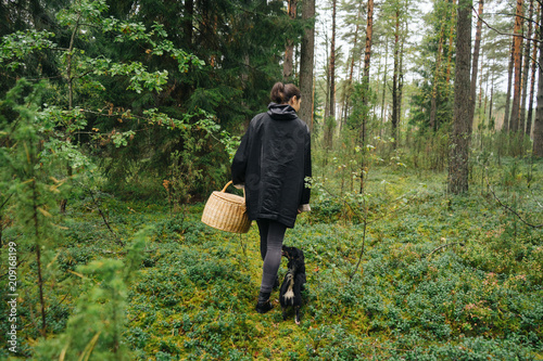 Girl walking on the forest with her dog. photo