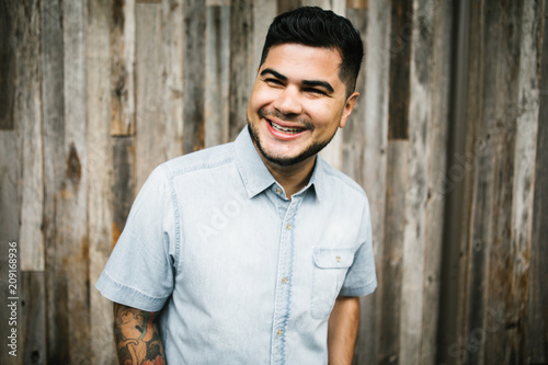 Portrait of Happy young hispanic - latino man in city photo