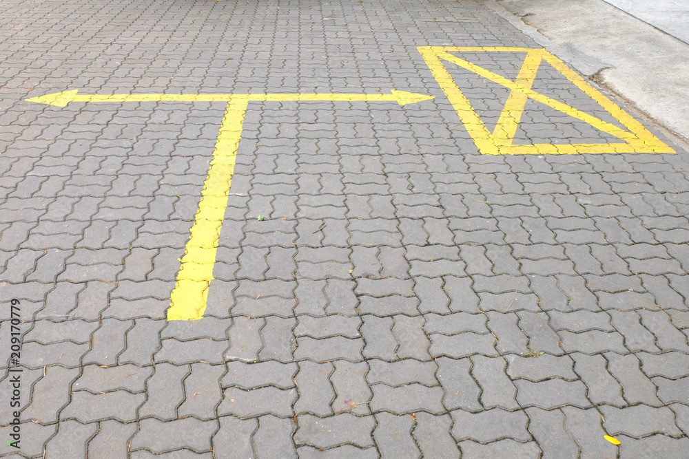 The yellow junction mark on the concrete floor.