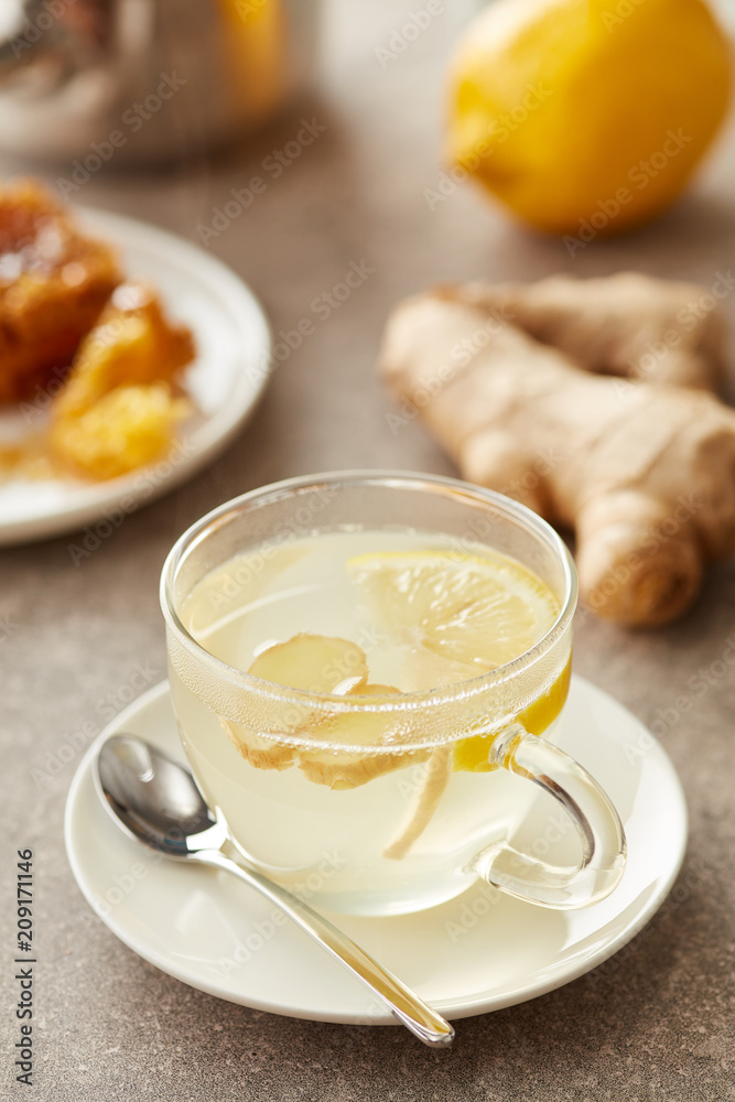 Glass of tea made of lemon, honeycomb and ginger root on table. Glass of tea made of lemon, honeycomb and ginger root on table.