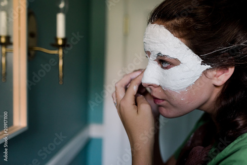 teen girl creating a mask/masquerade (in mirror) photo