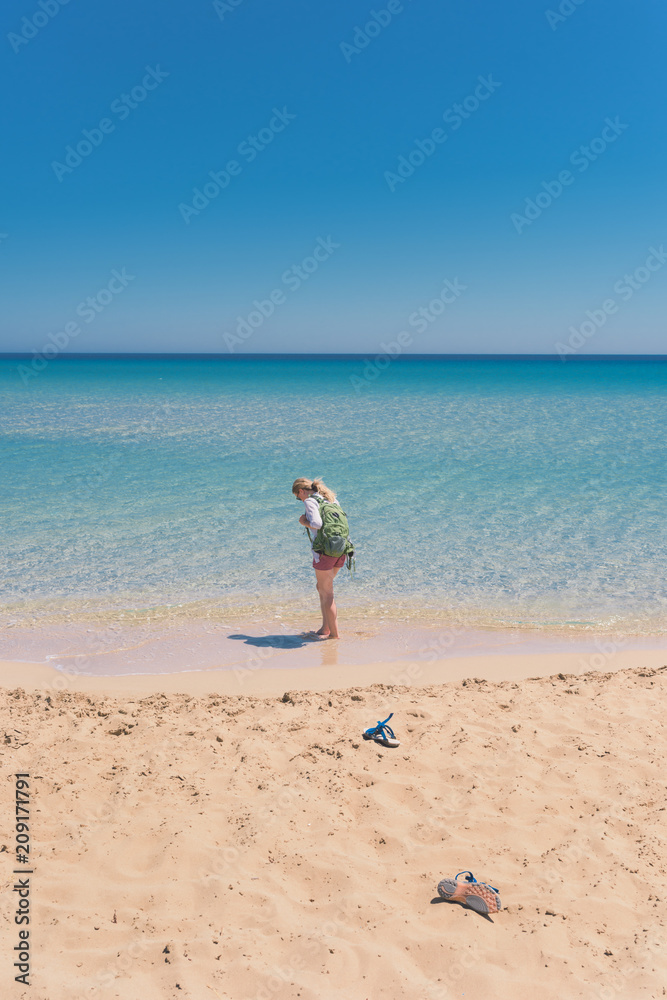 YoungfFemale tourist wandering in shallow sea water YoungfFemale tourist wandering in shallow sea water