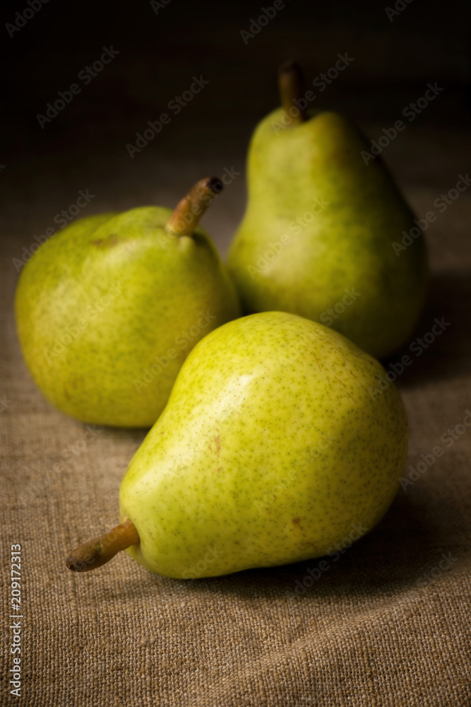 three rustic pears on a board with spices