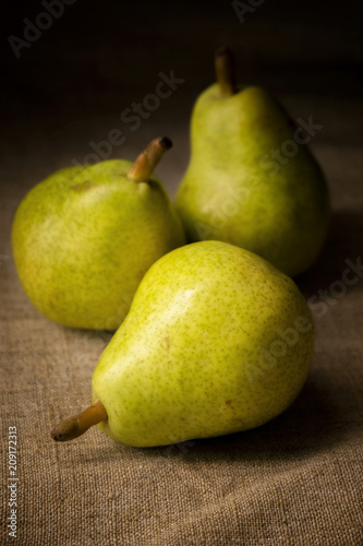 three rustic pears on a board with spices