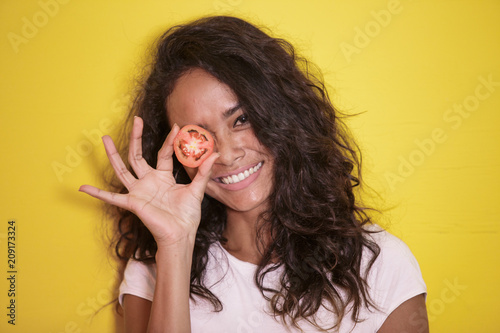 beautiful asian woman smilingwith slices of tomato